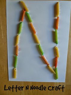 the letter n is made out of carrots and toothpicks on a sheet of paper