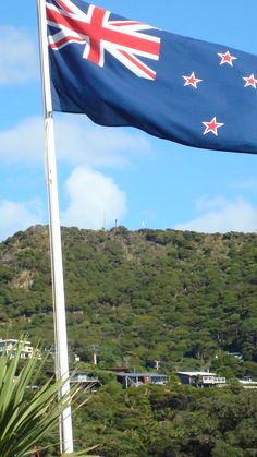 an australian flag flying in front of a lush green hillside