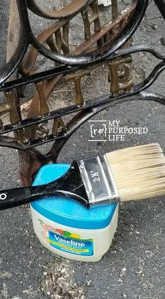 the brush is sitting on the ground next to an old bench with rust and paint