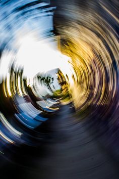 an abstract photo of a circular object with blurry lights in the middle and blue sky above