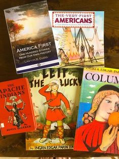 several children's books sitting on top of a wooden table next to each other