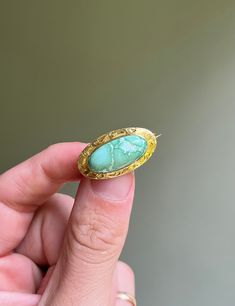 * Antique 1900's Art Nouveau era, American handmade brooch, made of solid 14 carat gold, framing a natural unstabilized light greenish blue turquoise cabochon. Adorned by traditional scroll etch detailing along the border of the brooch.  * No stampings or hallmarks, common for antique pieces of this age.  * Measurements- 1.05 inches long x 0.57 inch wide  * Weight- 2.8 grams Turquoise Cabochon Brooch As A Gift, Turquoise Cabochon Brooch For Gift, Antique Yellow Gold Turquoise Cabochon Ring, Art Nouveau Yellow Gold Brooches Gift, Art Nouveau Yellow Gold Brooch Jewelry, Mc Gregor, Art Nouveau Filigree Brooch For Collectors, Art Nouveau Gold Brooch With Cabochon, Luxury Collectible Art Nouveau Brooch