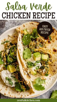 two chicken tacos with avocado and cilantro on top, sitting on a white plate