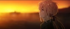 a person with blonde hair standing in front of a sunset