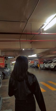 a woman is walking through a parking garage