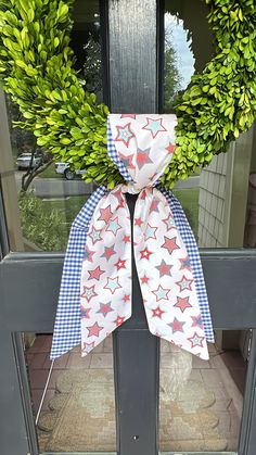 a wreath with red, white and blue stars is hanging on the front porch door