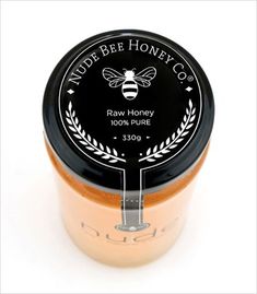 a jar of honey sits on a white surface with the label made bee honey co