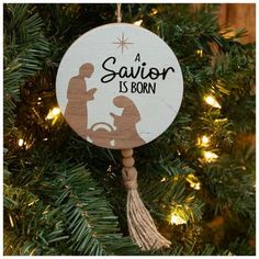 a wooden ornament hanging from a christmas tree with a nativity scene on it