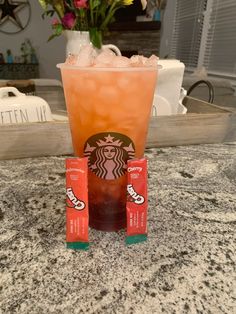 two drinks sitting on top of a counter next to each other with flowers in the background