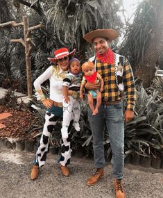 two adults and one child are dressed up as toy story characters in front of plants