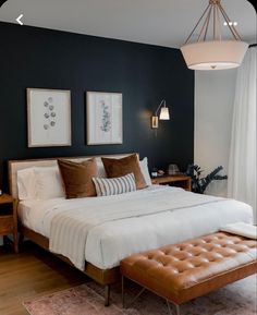 a bedroom with a large bed and two pictures on the wall