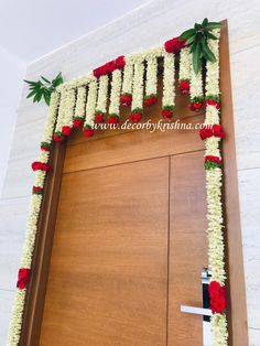 a door decorated with flowers and greenery for an entrance to a building or office