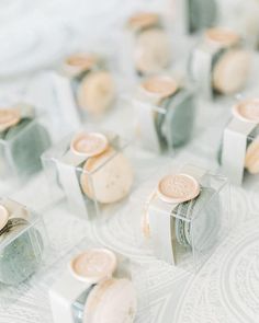 several different types of buttons in small plastic containers on a table with white and gray patterns