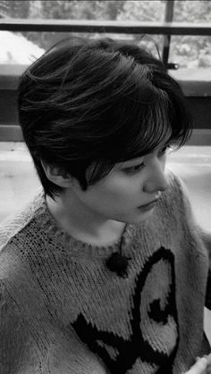 black and white photograph of a woman with short hair wearing a sweater looking off to the side