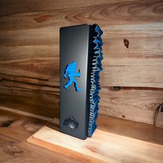 a blue and black object sitting on top of a wooden table next to a wall