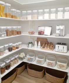 an organized pantry filled with lots of food and storage bins on the shelves above