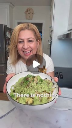 a woman holding a bowl filled with food