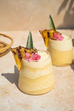 two glasses filled with dessert sitting on top of a table