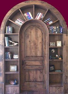 an arched wooden door with books on shelves