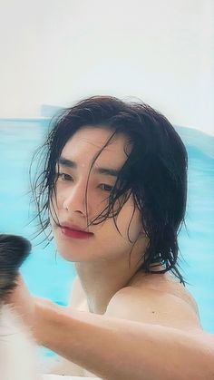 a young man is brushing his hair in the pool