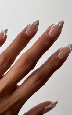 Get inspired by 30+ adorable bow nail designs, from cute 3D bow nails to short and sweet styles in pink, red, white, gold, and black. This also includes coquette nails, ribbon nails, short bow nails, french tip bow nails, bow nail art. (📷 overglowedit IG) Classic December Nails, Nails Inspiration December, French Tips With A Design, White Nails With Bow Design, Winter Nail Ideas White, Pearl Bow Nails, 3d Bow Nail Art, White French Tips With Bow, French Bow Nails