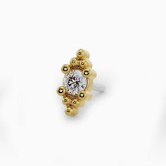 If you can't go to Bail, we'll bring Bali to you. Inspired by the exotic locale's motifs, this golden end is sure to shine in cartilage, nose, and lip piercings. The center diamond is hugged by the delicate beaded accents, providing a sense of balance and security. 1.3mm (0.011ct) conflict-free genuine diamond Diamond Clarity: VS1 (ideal), G-H color Solid 14k gold | Nickel-free | Hypoallergenic The pin post is made of 316 LVM stainless steel for durability when bending. Ethically handmade in the Anniversary Yellow Gold Cubic Zirconia Piercings, Yellow Gold Diamond Cartilage Earrings, Yellow Gold Nose Studs With Prong Setting, 14k Yellow Gold Cartilage Earrings With Diamond Accents, Gold Cubic Zirconia Fine Jewelry Piercings, Diamond Fine Jewelry Piercings For Anniversary, Yellow Gold Round Nose Studs With Prong Setting, Diamond Piercings In White Gold For Anniversary, Diamond White Diamond Piercings For Anniversary