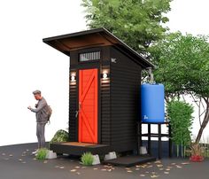 a man standing in front of a tiny house next to a blue and red water tank