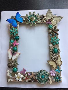 a photo frame decorated with butterflies and beads