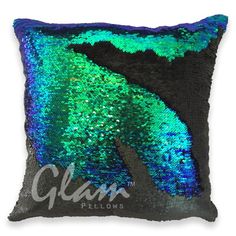 a green and blue sequinized pillow with the word glam pillows on it