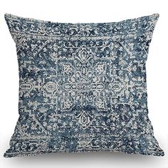 a blue and white pillow with an intricate design on the front, sitting against a white background