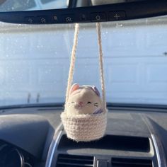 a car dashboard with a stuffed animal hanging from the dash board