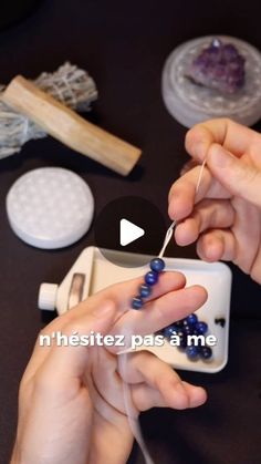 a person is knitting beads on a table