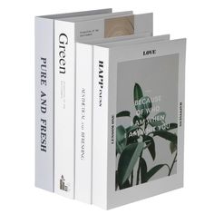 three books are stacked on top of each other, one is white and the other is green