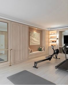 there is a gym with exercise equipment in the room and mirrors on the wall behind it