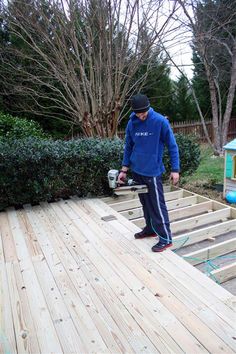 a man standing on top of a wooden deck