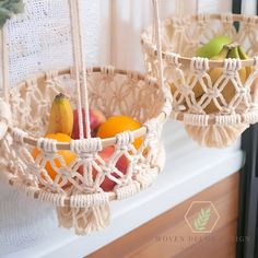 two hanging baskets filled with fruit on top of a window sill