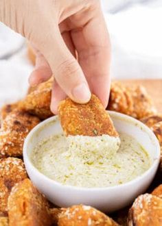 a person dipping something into a small white bowl