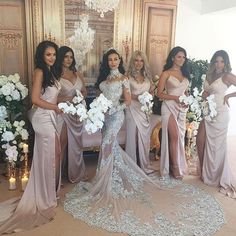 the bride and her bridesmaids pose for a photo in their wedding gowns