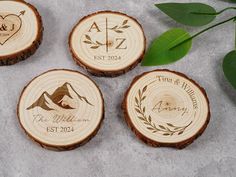 four personalized wood coasters with the names and date engraved on them, surrounded by greenery