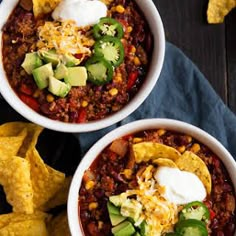 two bowls filled with chili, cheese and tortilla chips