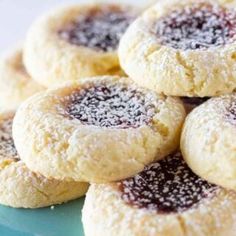 a pile of cookies sitting on top of a blue plate covered in powdered sugar