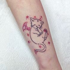 a small cat tattoo on the left forearm and leg, with stars around it's ankles