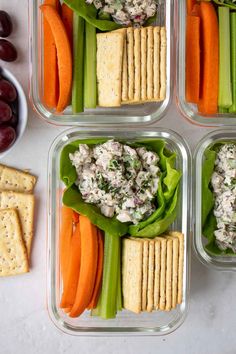 four plastic containers filled with vegetables and crackers