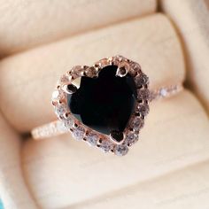 a heart shaped black diamond ring in a box