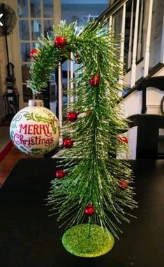 a christmas tree made out of tinsel and ornaments on top of a black table