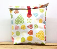 a colorful bag sitting on top of a wooden table next to a white wall with polka dots