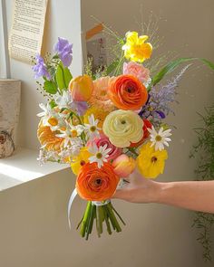 a person holding a bouquet of flowers in their hand