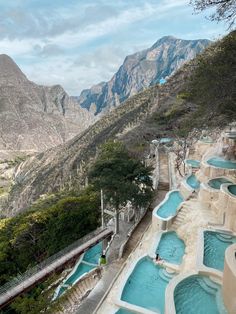 an outdoor swimming pool with mountains in the background