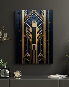 a gold and blue art piece on a wall next to a vase with flowers in it