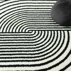 a black and white rug with a bean bag sitting on the floor next to it